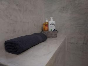 - une serviette et une bouteille de savon sur un comptoir dans l'établissement Aggeliki's place detached home with yard/parking, à Vólos