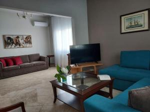a living room with a couch and a coffee table at Aggeliki's place detached home with yard/parking in Volos
