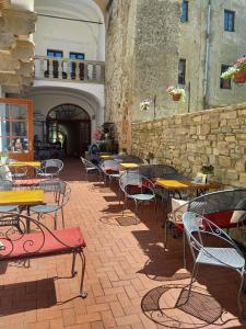 an outdoor patio with tables and chairs and a stone wall at Residence Spillenberg Apartment 1A in Levoča