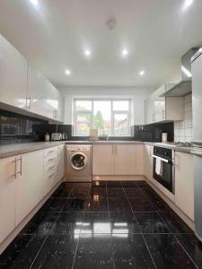a large kitchen with a washer and dryer in it at Home in the Heart of Manchester in Manchester