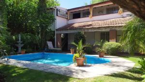 una villa con piscina frente a una casa en EL oasis Depto, en Córdoba