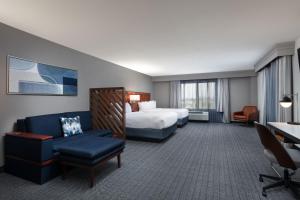 Habitación de hotel con cama y silla en Courtyard by Marriott Wichita at Old Town, en Wichita