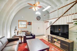 a living room with a large television and a staircase at Charming Bay St Louis Home Deck, on Canal! in Shoreline Park