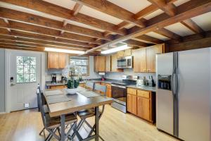 a kitchen with a table and a refrigerator at Charming Bay St Louis Home Deck, on Canal! in Shoreline Park