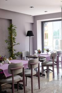 un comedor con mesas y sillas púrpuras en THE ROYALS HOTEL en İzmir