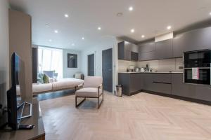 a living room with a couch and a kitchen at Urban Chic Central Studio in Reading Centre CHRL F7 in Reading