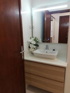ein Bad mit einem Waschbecken und einem Spiegel in der Unterkunft Buddies Charm House in Aveiro