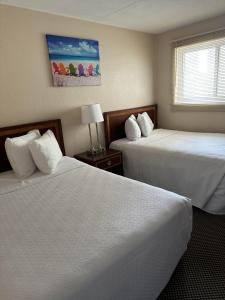 a hotel room with two beds and a window at Diamond Crest Motel in Wildwood Crest