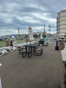 un grupo de mesas de picnic con sombrillas en un patio en Diamond Crest Motel, en Wildwood Crest