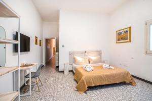 a bedroom with a bed and a desk and a television at Suite Mariagiovanni in Lecce