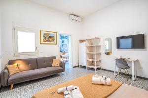 - un salon avec un canapé et une télévision dans l'établissement Suite Mariagiovanni, à Lecce