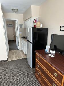eine kleine Küche mit einem schwarzen Kühlschrank und einem TV in der Unterkunft Diamond Crest Motel in Wildwood Crest