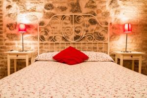 um quarto com uma cama com uma almofada vermelha em Casa de Gaitán em Toledo