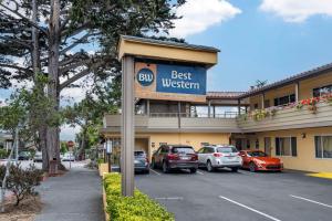 a best western hotel with cars parked in a parking lot at Best Western Carmel's Town House Lodge in Carmel