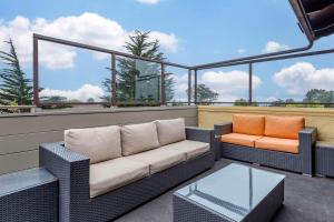 a couch and two chairs sitting on a balcony at Best Western Carmel's Town House Lodge in Carmel