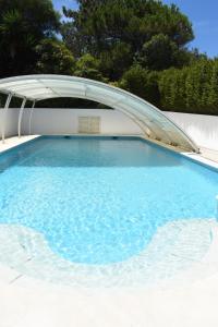 uma grande piscina com um telhado curvo em Ericeira Living na Ericeira