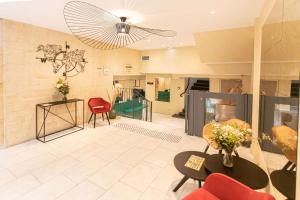 a living room with a table and chairs and a ceiling at Quality Hotel Bordeaux Centre in Bordeaux
