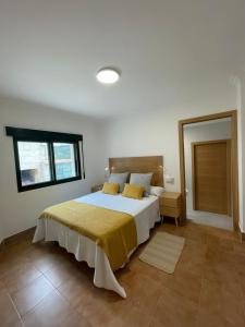 ein Schlafzimmer mit einem großen Bett mit einer gelben Decke in der Unterkunft LA CASA DE DORA EN LA ESCUSA in Armentera + 23 Fotos