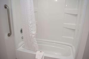 um chuveiro branco com uma cortina de chuveiro branca na casa de banho em Comfort Inn & Suites Syracuse-Carrier Circle em East Syracuse