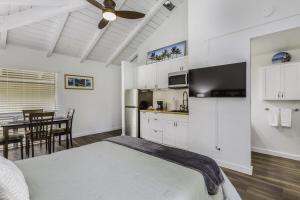 a bedroom with a bed and a kitchen with a table at Sandpiper 216B condo in Princeville