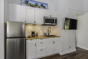 a kitchen with white cabinets and a stainless steel refrigerator at Sandpiper 216B condo in Princeville