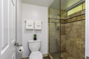 a bathroom with a toilet and a glass shower at Sandpiper 216B condo in Princeville