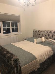 a bedroom with a bed with a couch and a window at Croydon Near London in Shirley