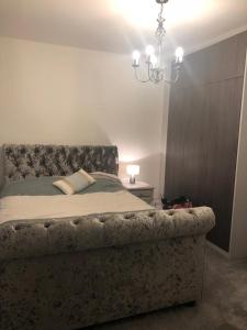 1 dormitorio con cama y lámpara de araña en Croydon Near London en Shirley