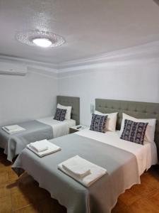 a room with two beds with towels on them at Residencial Antonio Mocisso Guesthouse in Elvas