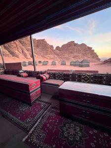 a room with beds and a view of the desert at um sabatah Camp in Wadi Rum