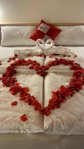 serce zrobione z czerwonych róż na łóżku w obiekcie Millennium Stube Locazione Turistica w mieście Zovencedo