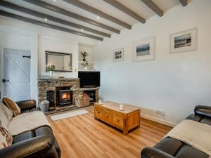 sala de estar con 2 sofás y chimenea en Stable Cottage - Uk10694 en Amroth