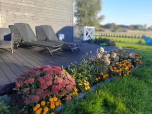 eine Terrasse mit Stühlen und Blumen im Hof in der Unterkunft Domek Lawendowe Wzgórze in Mielenko