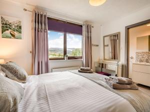 a bedroom with a large white bed with a window at Highview in Brodick