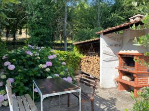 un jardín con mesa y horno de ladrillo en A Casiña, en Monforte de Lemos