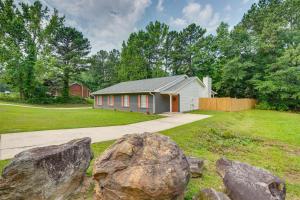 a house with a large rock in the yard at Atlanta Getaway with Private Yard 3 Mi to Airport in College Park