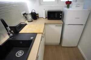 ワルシャワにあるapART!mentのシンクと冷蔵庫のある小さなキッチン +10枚の写真