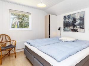 Un dormitorio con una cama grande y una ventana en Holiday Home Kallesensvej, en Blåvand