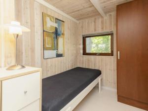 イェアティングにある6 person holiday home in Esbjerg Vのベッドと窓が備わる小さな客室です。