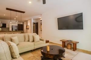 ein Wohnzimmer mit einem Sofa und einem Tisch in der Unterkunft Luxury Aldea Zama 2bed - 2bat Apartment Private Terrace & Swim Up in Tulum