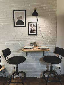 a table and chairs against a white brick wall at Modernes Wohlfühl-Apartment an den Kaiserthermen in Trier