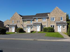 a large brick house with white doors on a street at ClariTurf - 4 Bedroom Semi with Sky and Netflix near Turf Moor Football Stadium, Burnley Town Centre and Transport Links next to Canal, Parks and Lake in Burnley