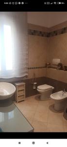 een badkamer met 2 wastafels, een toilet en een raam bij Next to station for Florence in Montelupo Fiorentino