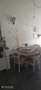 a table and chairs in a room with a tree on the wall at Next to station for Florence in Montelupo Fiorentino