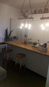 a kitchen with a counter with two stools and lights at Next to station for Florence in Montelupo Fiorentino