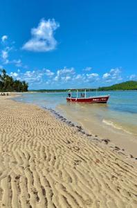 a boat sitting on the shore of a beach at Flat Eco Resort Carneiros in Praia dos Carneiros