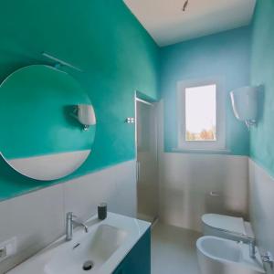 een badkamer met een witte wastafel en een spiegel bij Villa immersa nelle colline toscane, vista vigneto in Cortona