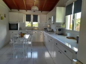 a kitchen with white cabinets and a table in it at akaixora -ixora in Le Moule