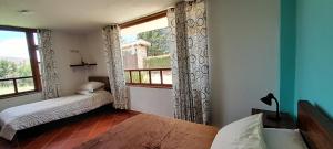 1 dormitorio con 2 camas y ventana grande en Cabaña Campestre el Refugio en Villa de Leyva