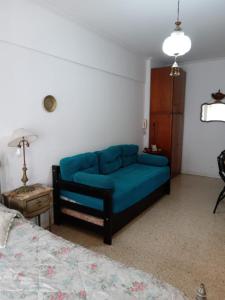 um sofá azul num quarto com uma cama em 4E Muy cerca del MAR em Mar del Plata